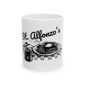 Puede incluir: Taza de cerámica blanca con una ilustración en blanco y negro de panqueques, jarabe y el texto "St. Alfonzo's". El diseño recuerda a un menú de restaurante. Ideal para bebidas calientes.