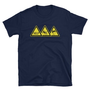May include: Navy blue t-shirt with three yellow hazard signs. The first sign reads "HELP", the second depicts a person slipping, and the third features a man in a fedora. The shirt is a short-sleeved crew neck.