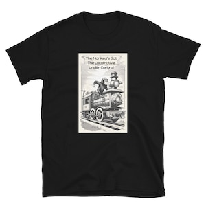 May include: Black t-shirt with a monochrome illustration of a monkey driving a train. The image includes the text "The Monkey's Got The Locomotive Under Control". The design is printed on the front of the shirt.
