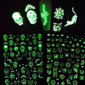 May include: Glow-in-the-dark nail stickers featuring Halloween designs. The stickers include skulls, snakes, spiders, and spiderwebs.