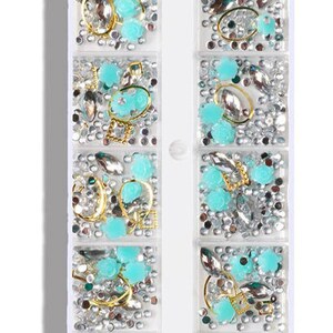 Op de afbeelding: Een doorzichtige plastic container met 10 vakken gevuld met zilveren en turquoise nagelkunstversieringen. De container heeft de tekst "CapreDiemNail B-01" onderaan gedrukt.