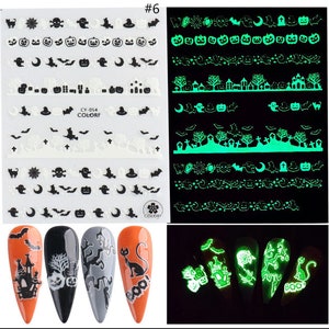 May include: Halloween nail art stickers with glow-in-the-dark designs. The stickers feature various spooky elements like ghosts, bats, pumpkins, and haunted houses. The stickers are shown on a set of nails with different designs.