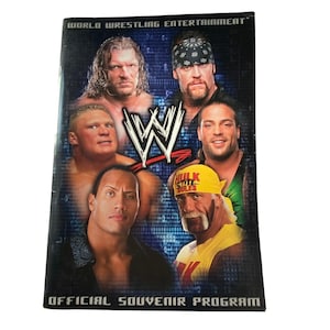 May include: Official souvenir program featuring multiple World Wrestling Entertainment (WWE) wrestlers. The cover displays a collage of wrestler portraits, the WWE logo, and the text "World Wrestling Entertainment".