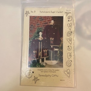 Puede incluir: Una bolsa de plástico que contiene un patrón de costura para una chaqueta de ángel patchwork. La portada presenta una foto de una chaqueta burdeos con apliques de ángeles. El texto incluye "No. 19 Patchwork Angel Jacket" y "Serendipity Gifts".