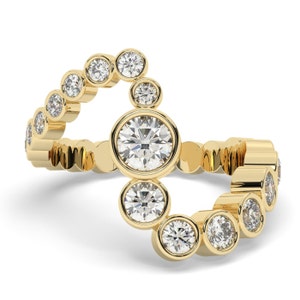 May include: A gold ring with a cluster of round diamonds. The diamonds are set in a bezel setting and are of varying sizes. The ring is a delicate and elegant piece of jewelry.