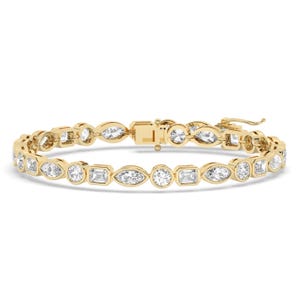 May include: A gold bracelet with a variety of clear, sparkling gemstones in different shapes, including round, oval, and rectangular. The bracelet has a secure clasp and is designed for everyday wear or special occasions.