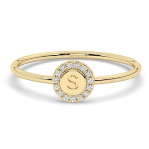 Peut inclure: Une bague en or avec un halo rond de diamants pavés entourant une lettre "S". La bague est gravée du mot "AZALEA".