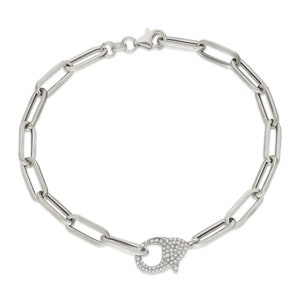 May include: A silver chain bracelet with a silver clasp set with clear cubic zirconia stones.
