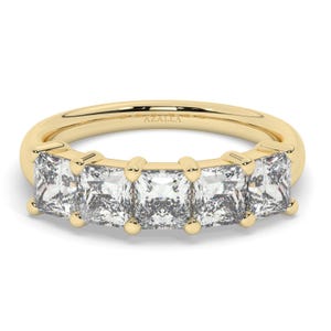 May include: A gold band ring with five square-shaped diamonds set in a row. The ring is engraved with the word "AZALEA".