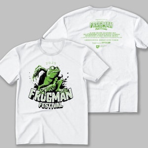 May include: White t-shirt with a green frog graphic and the text "2025 FRUGMAN FESTIVAL". The back of the shirt has the text "FRUGMAN FESTIVAL" and the words "Brought to you by CRYPTIC CAMP".