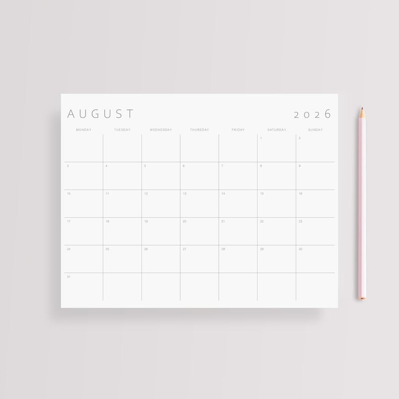 Close-up of a single 2026 monthly planner page printed on US Letter size paper, landscape format, minimalist design with clean grey lines and grey modern typography, held gently by a hand.