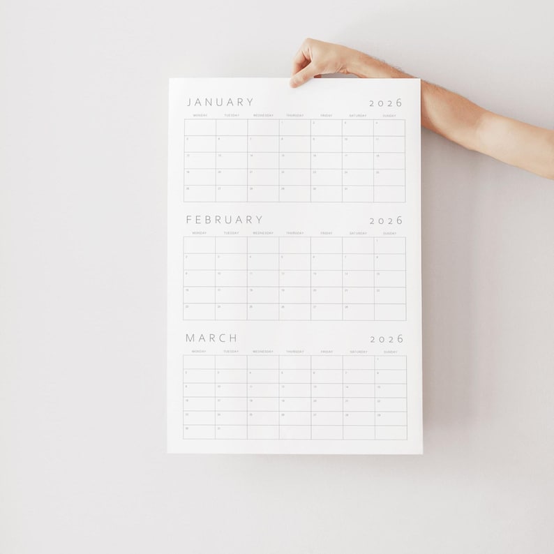 One quarter of the 2026 yearly planner in portrait orientation, featuring three months per page with light grey font and minimalist line layout, printed on white paper photographed on a neutral background.