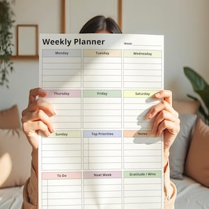 May include: A white weekly planner with sections for each day of the week, top priorities, notes, to-do list, and gratitude. The planner has a simple design with pastel color accents and the text "Weekly Planner".