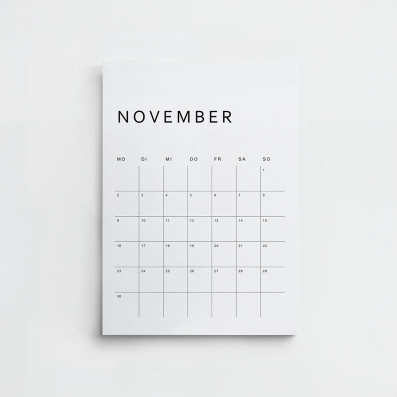 Gedruckte Seite des minimalistischen deutschen Kalenders 2026, ein Monat im Hochformat, schwarze Linien, moderne Schrift, weißes A4-Papier auf hellem Holzuntergrund fotografiert.