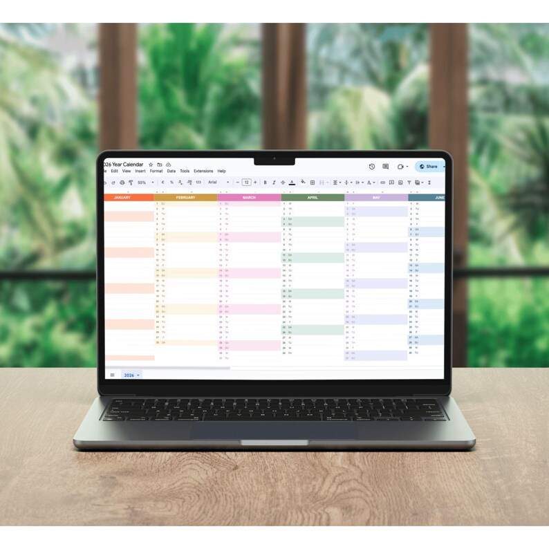 Modern laptop on desk displaying 2026 editable Excel calendar template with color-coded months and task tracker