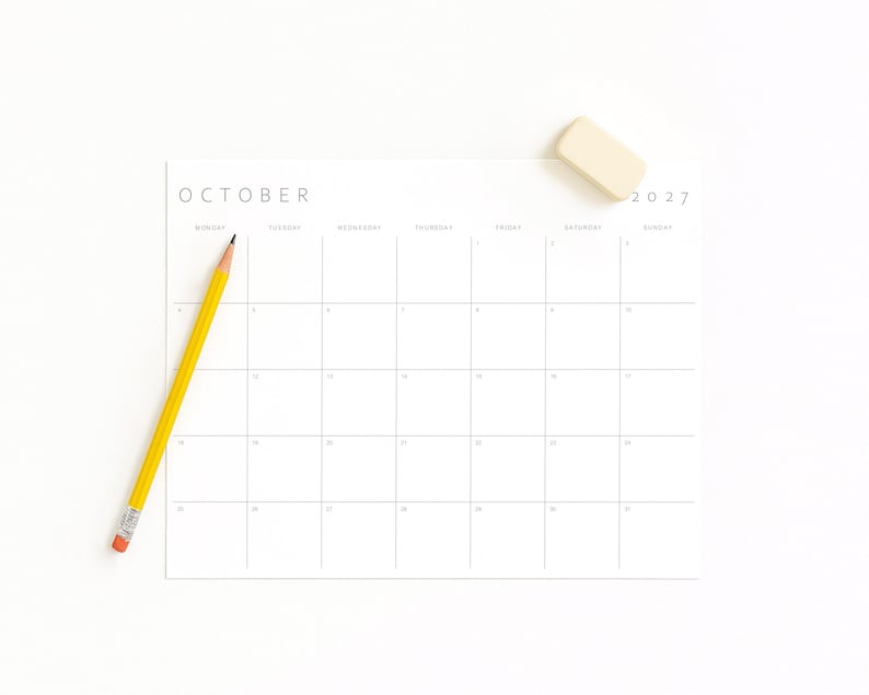 October 2027 printable monthly calendar displayed on a white surface with a yellow pencil and eraser.