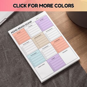 Op de afbeelding: Een wit notitieblok met de tekst "ADHD BRAIN DUMP" en secties voor taken zoals "To Call", "To Email" en "To Do Today". Het notitieblok heeft een kleurrijk ontwerp met secties in oranje, paars en blauw. De tekst "CLICK FOR MORE COLORS" staat bovenaan.