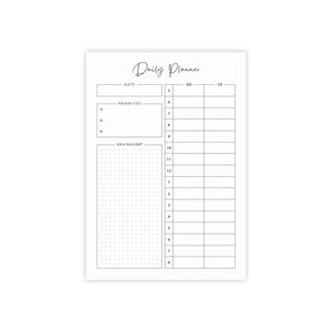May include: A white daily planner with the words "Daily Planner" in cursive script at the top. The planner includes sections for date, priorities, a brain dump, and hourly scheduling from 5:00 AM to 8:00 PM.