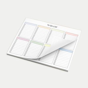 May include: A white To Do List notepad with a pastel color-coded layout. Each section has a checklist and lines for writing. The top sheet is partially lifted, revealing the pages beneath. The notepad is designed for organizing tasks.
