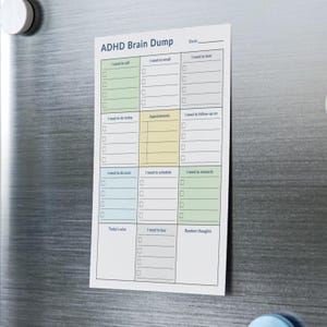 Flat-lay of physical sticky notes pad with printed daily checklist layout — includes labeled sections for planning, calls, appointments, and brain dump, displayed on a neutral background.