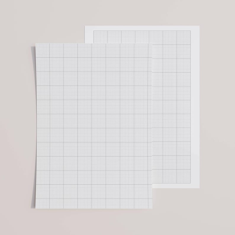 A printed letter-size sheet with ten by ten grid lines, resting on a wooden table, photographed under daylight to highlight the fine line pattern and smooth paper texture.