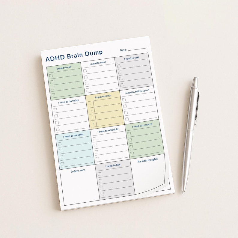 A 4x6 inch ADHD planner sticky note pad on a white desk, showing color-coded sections for brain dump, calls, appointments, and tasks, with soft pastel headers and clean minimalist daily organization layout.