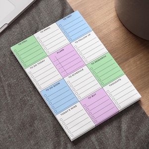 Peut inclure: Un bloc-notes coloré avec des sections pour la planification et l'organisation. Le bloc-notes comporte des sections intitulées "To Call", "To Email", "To Text", "To Do Today", "Plans", "To Follow Up", "To Do Soon", "To Schedule", "To Research", "Today's Wins", "To Buy" et "Thoughts."