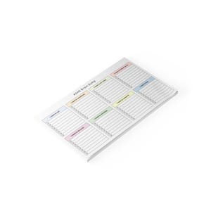 Top view of a 10x6 inch printed ADHD brain dump notepad with pastel colored section headings and checkboxes, placed on a desk with a pen, showing a clean productivity layout.