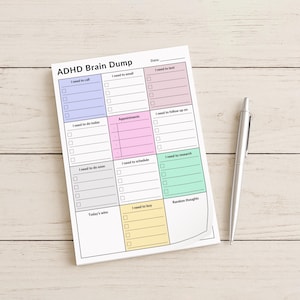 Flat lay of a colorful ADHD sticky notes pad on a minimal desk setup, displaying a single page with labeled sections for organizing tasks, appointments, calls, and brain dump entries.