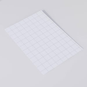 Flat lay of printable 10 squares-per-inch graph paper on light beige surface, displaying the uniform grid layout and margin area at the top of the page.