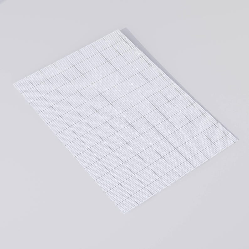 Flat lay of printable 10 squares-per-inch graph paper on light beige surface, displaying the uniform grid layout and margin area at the top of the page.