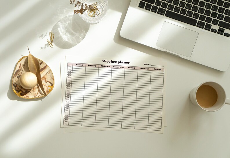 Gedruckter Wochenplan mit Zeitplan auf weißem Papier, halbstündliche Zeitfelder und klare Spaltenstruktur von Montag bis Sonntag, minimalistische Liniengestaltung.