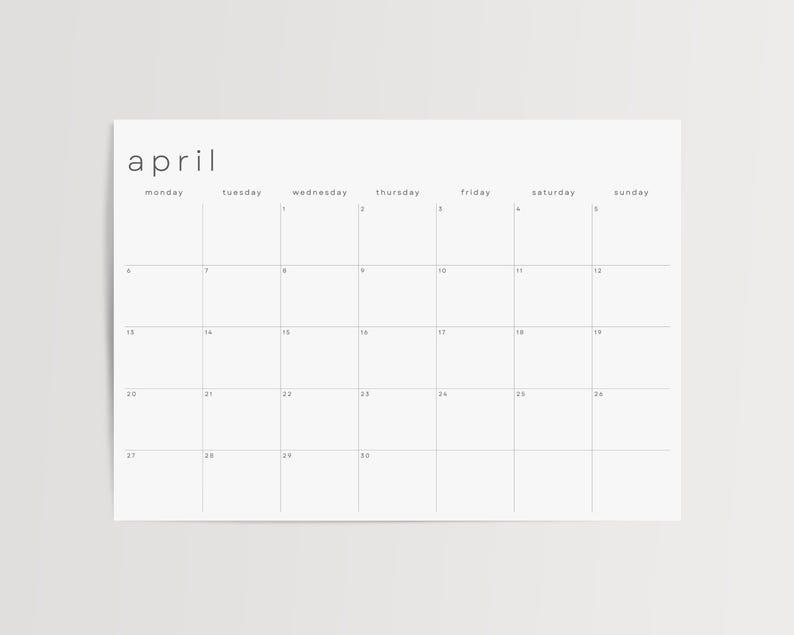 Minimalist July 2026 monthly page displayed on semi-gloss paper against grey tabletop. The landscape planner shows a thin-line grid, weekday labels along the top, and uniform date numbers.