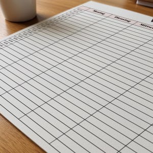 Wochenplaner mit halbstündlichen Zeitfeldern auf weißem Papier, klare Spaltenstruktur von Montag bis Sonntag, minimalistisches Design mit dünnen Linien und rosa Spaltenüberschriften.