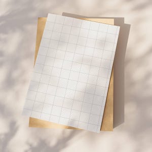 Two sheets of ten squares-per-inch graph paper, one version with margin and one without, shown side by side on a neutral white background, displaying line thickness and spacing.
