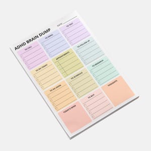 A brain dump sticky note pad designed for ADHD, lying flat on a desk, showing multiple empty sections ready for writing. Minimal 4x6 Post-it format with clean lined structure.