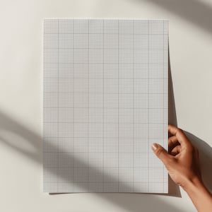 Close-up of letter-size grid paper printed with a 10 by 10 squares-per-inch pattern, displayed flat on a white background with precise thin lines and a clean, minimalist layout.