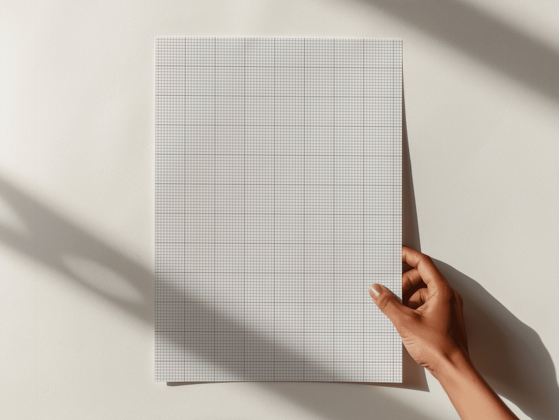 Close-up of letter-size grid paper printed with a 10 by 10 squares-per-inch pattern, displayed flat on a white background with precise thin lines and a clean, minimalist layout.