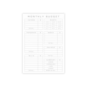 May include: A white, rectangular "MONTHLY BUDGET" planner with a minimalist design. The layout includes sections for income, expenses, debts, savings, and bills, with corresponding spaces for amounts in pounds. Months are listed across the top, with a summary section at the bottom.
