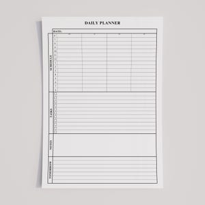 Minimalist daily planner printable in portrait orientation, open on a laptop and tablet for home office organization.
