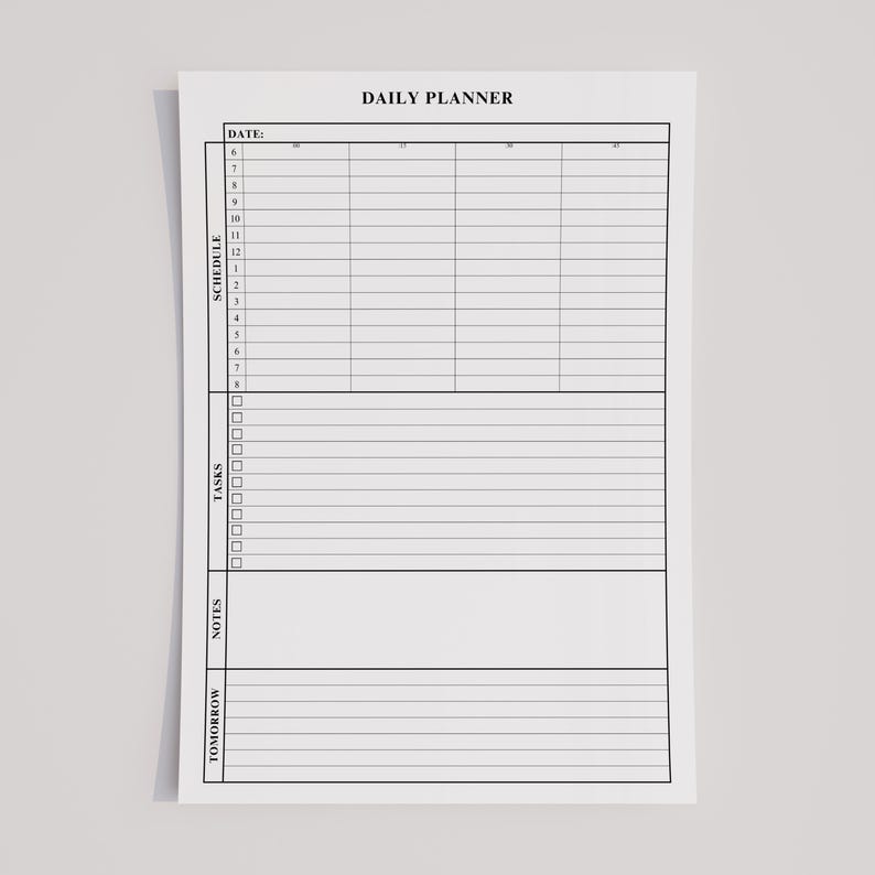 Minimalist daily planner printable in portrait orientation, open on a laptop and tablet for home office organization.