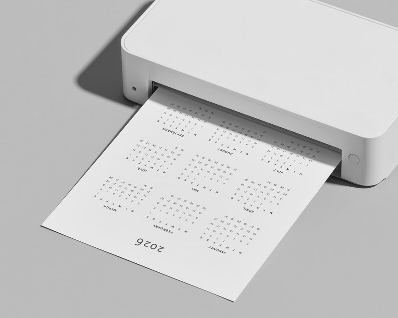Printable 2026 yearly calendar sheet displayed on US Letter paper with clean grid layout, minimal typography and full year overview, placed on a neutral workspace background with soft lighting