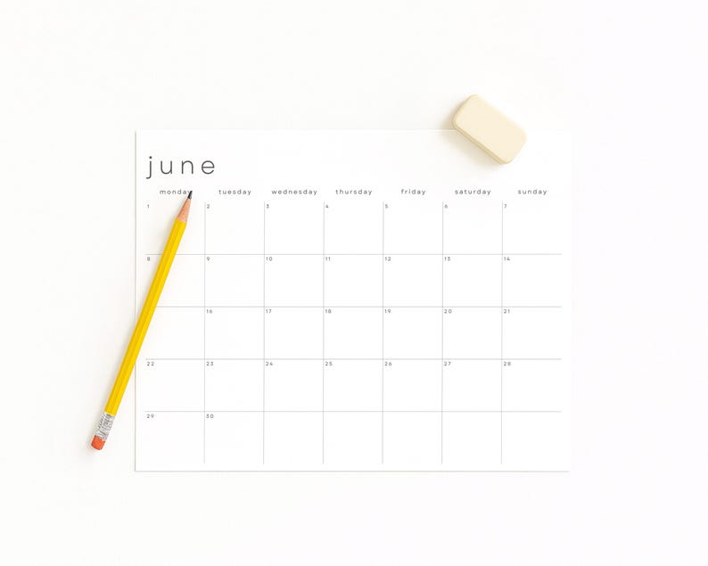 April 2026 monthly calendar sheet printed on matte paper, positioned on a cream desktop. Clean landscape design with pale lines, thin modern text, and Sunday start column visible on the left side.