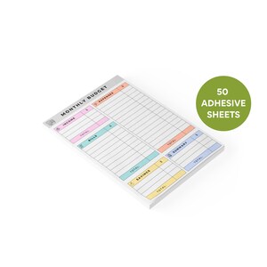 Close-up of compact sticky note notepad with colorful pastel headers, hand-drawn icons, and columns for income, bills, savings, and expenses, 50 tear-off sheets in a stack.