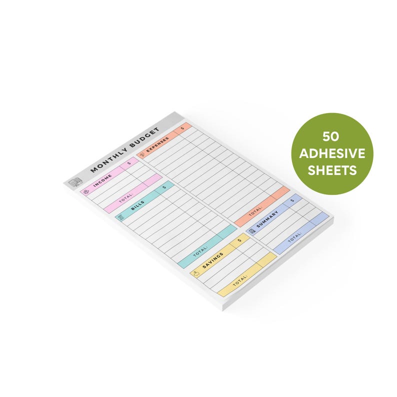 Close-up of compact sticky note notepad with colorful pastel headers, hand-drawn icons, and columns for income, bills, savings, and expenses, 50 tear-off sheets in a stack.