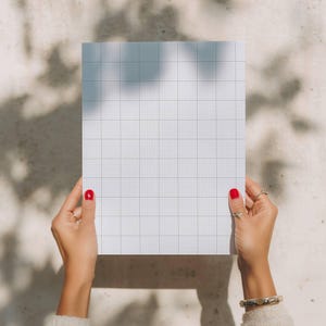 Printable graph-paper sheet with a dense 10x10 grid pattern, laid on a light background with visible small squares suitable for math, technical drawing, or note-taking.