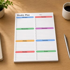 May include: A white weekly plan notepad with the title "Weekly Plan" at the top. The notepad has sections for each day of the week, with a space for notes. A pen and a cup of coffee are on the wooden surface.
