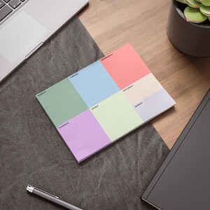 Könnte beinhalten: Ein farbenfroher Wochenplaner-Notizblock mit Abschnitten für jeden Wochentag. Der Notizblock hat Pastellfarben, darunter Grün, Blau, Rosa und Lila. Die Wochentage sind in einer einfachen Schriftart gedruckt. Der Notizblock liegt auf einer Holzoberfläche.