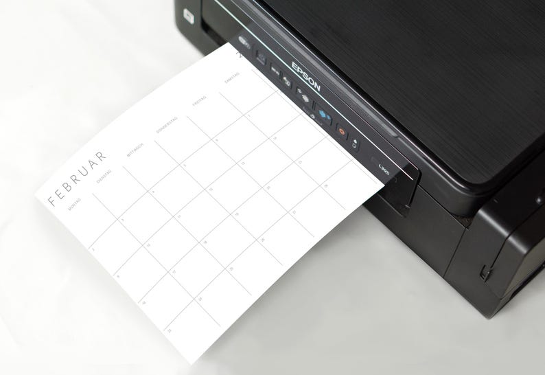 Hochauflösende A5 Kalenderseite 2026 in Querformat mit minimalistischer grauer Schrift und Linien auf weißem Papier, leicht geneigt auf neutralem Hintergrund.