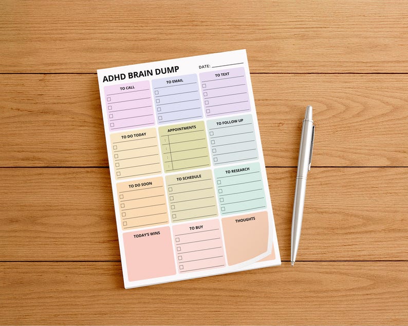 A 4x6 inch ADHD brain dump sticky note pad on a desk, showing a structured layout with labeled sections and checkboxes for thoughts, tasks, ideas, notes, and reminders printed on white paper.